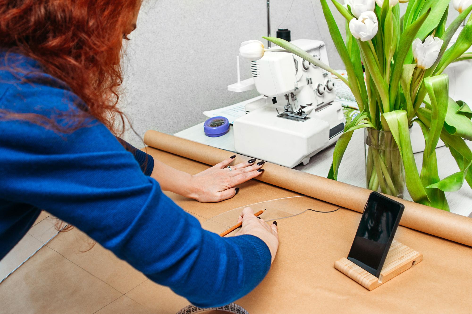 Mano che guida una macchina da ricamo su tessuto tecnico